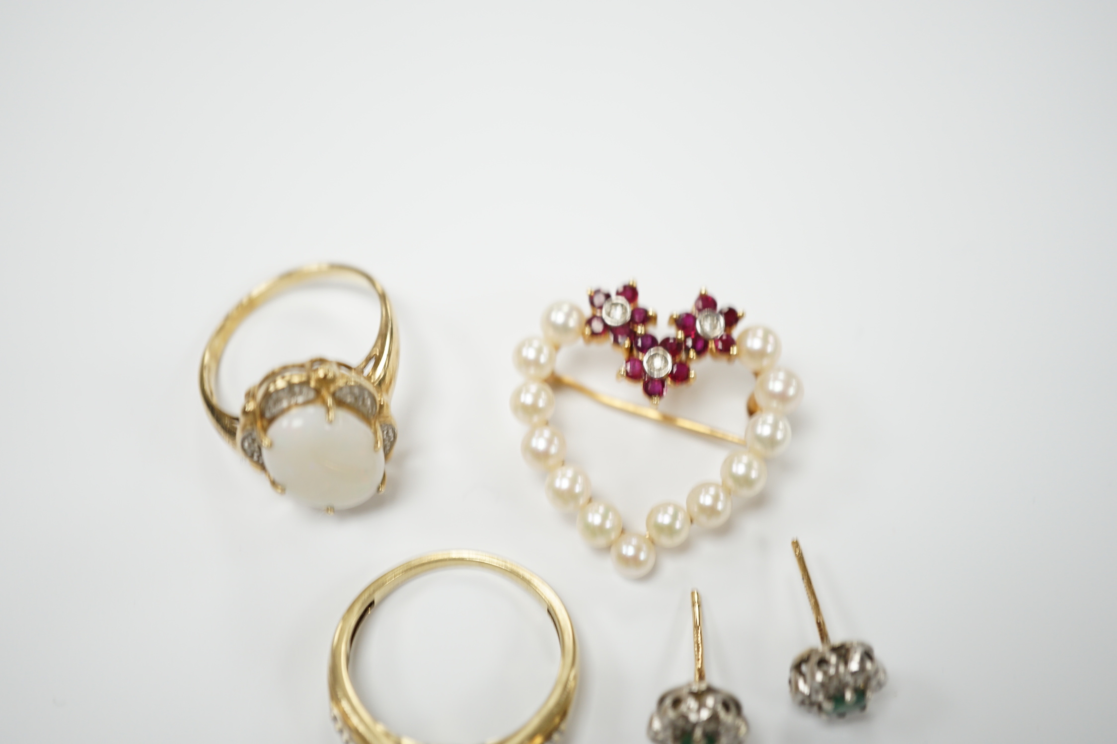 Two yellow metal and gem set rings, including diamond chip cluster and white opal and diamond chip cluster, together with a yellow metal, cultured pearl, ruby and diamond set open work heart shaped pendant brooch and a p
